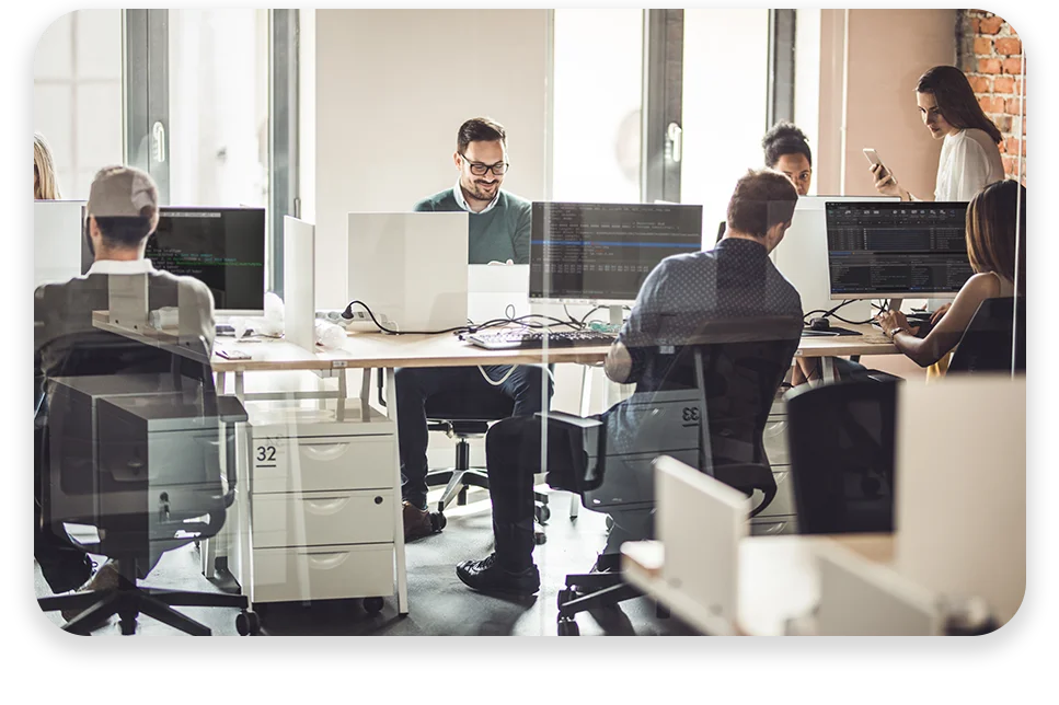 CPQ-Photo-with-two-patterns-three-modules2 An office with cool lighting and business coworkers sitting at a table in a meeting.