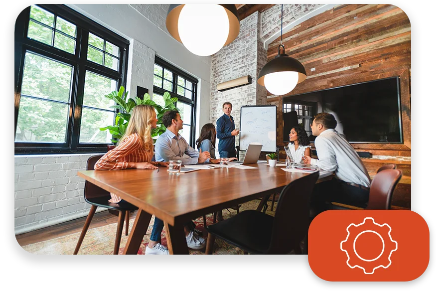 An office with cool lighting and business coworkers sitting at a table in a meeting.