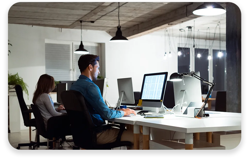 CPQ-Photo-with-two-patterns-three-modules2 An office with cool lighting and business coworkers sitting at a table in a meeting.