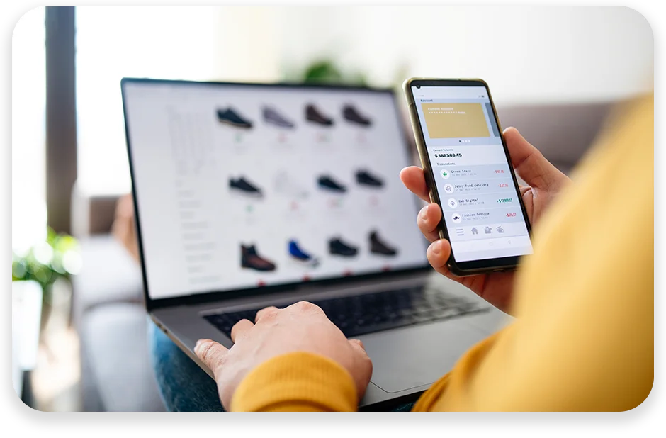 DC11 Een vrouw winkelt online op haar laptop en bekijkt tegelijkertijd de live voorraad op haar telefoon.