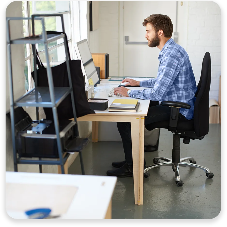 DC20 A man working on his computer in a well-lit office.